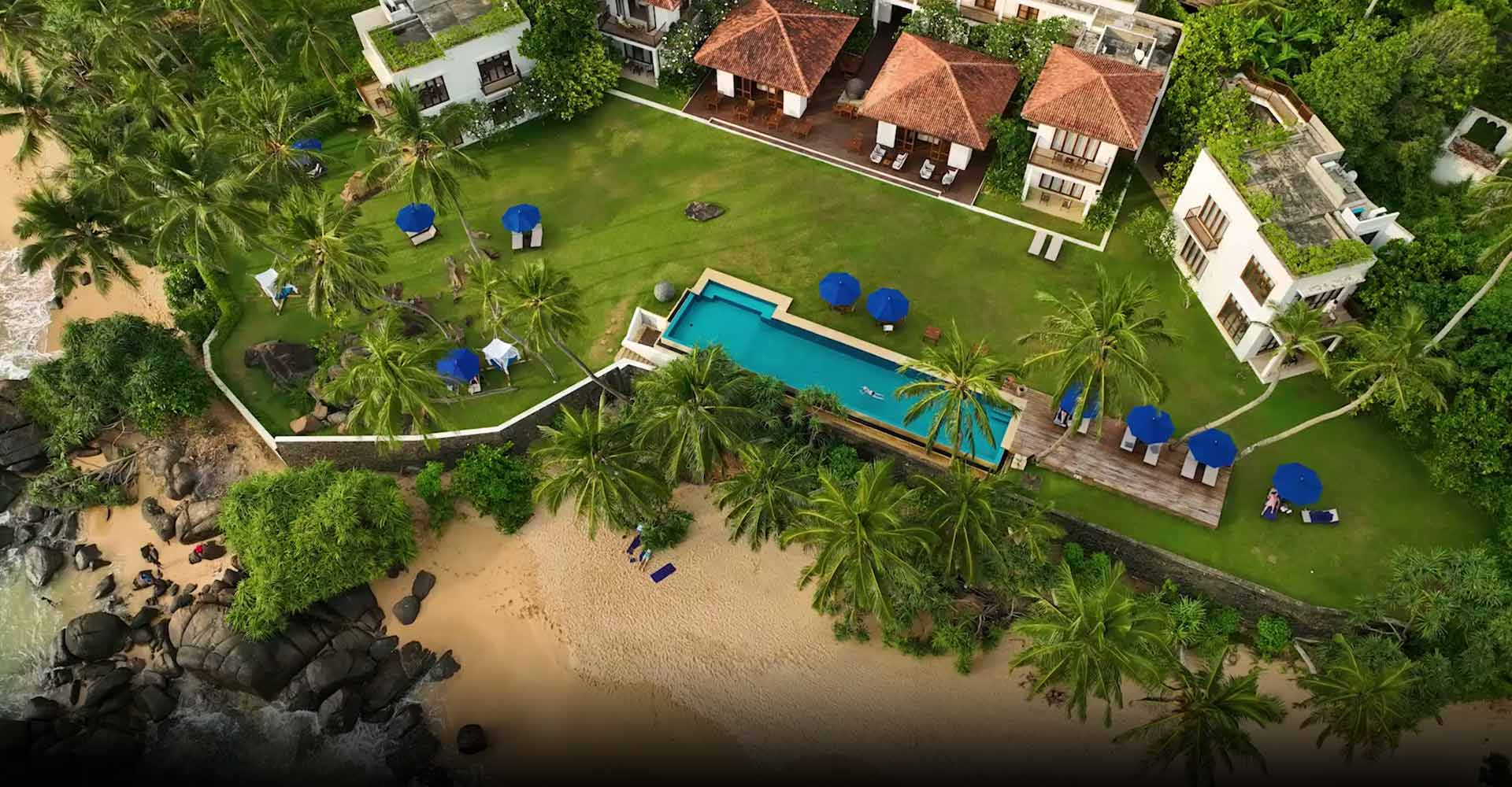 Kumu Beach, a luxury hotel in Balapitiya, with an infinity pool and a rocky beach with stunning ocean views.