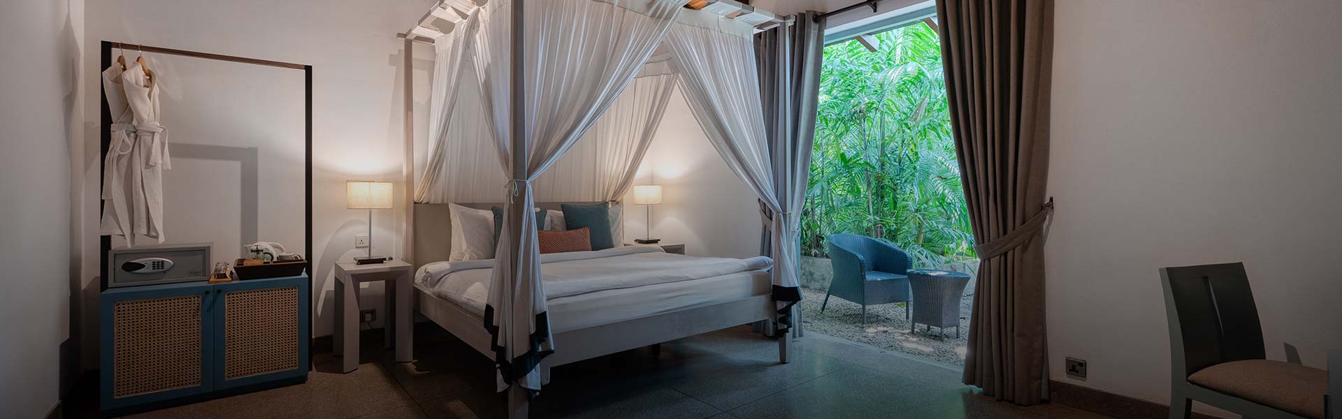 Spacious room with a canopy bed at Walawwa, offering luxury accommodation in Sri Lanka with a peaceful garden view.