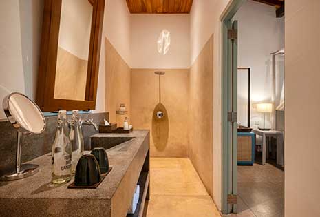 Stylish attached bathroom with a modern design and warm lighting at Walawwa, offering a relaxing luxury rooms in Colombo.